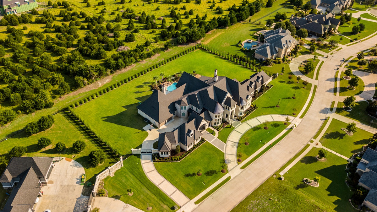 Aerial view of a house with a green backyard
